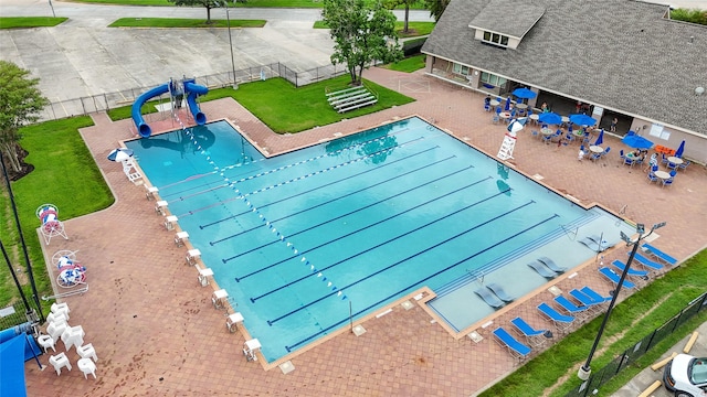 pool with a patio, fence, and a lawn
