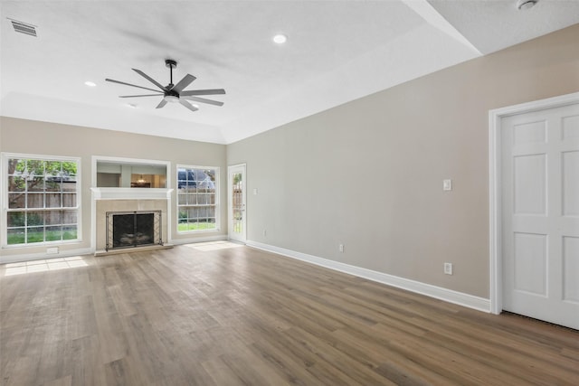 unfurnished living room featuring visible vents, baseboards, wood finished floors, and ceiling fan