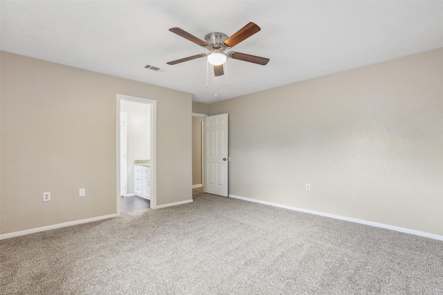 unfurnished bedroom featuring ceiling fan, carpet, ensuite bath, visible vents, and baseboards