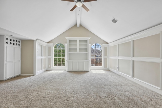interior space featuring vaulted ceiling with beams, ceiling fan, carpet, and visible vents