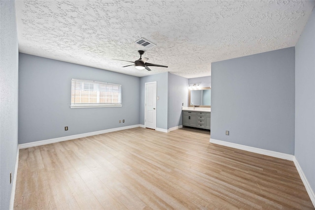 unfurnished bedroom featuring light wood-style floors, ceiling fan, baseboards, and visible vents