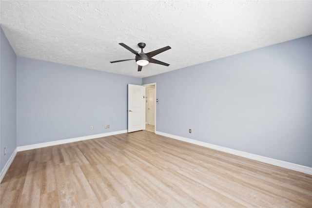 empty room with light wood-style flooring, baseboards, a textured ceiling, and ceiling fan