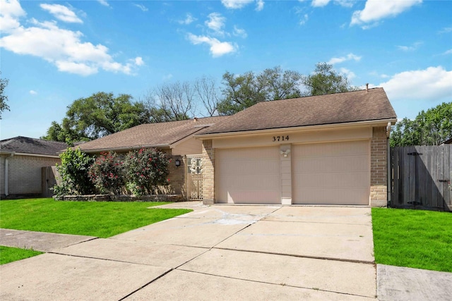ranch-style home with a garage, fence, brick siding, a front lawn, and roof with shingles