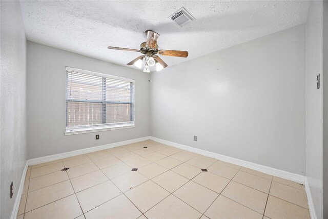 empty room with visible vents, baseboards, ceiling fan, a textured ceiling, and light tile patterned flooring