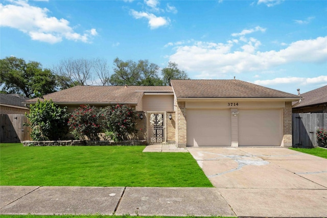 ranch-style house featuring concrete driveway, a front lawn, an attached garage, brick siding, and fence