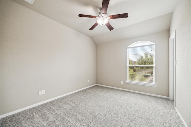 carpeted empty room with lofted ceiling, a ceiling fan, and baseboards