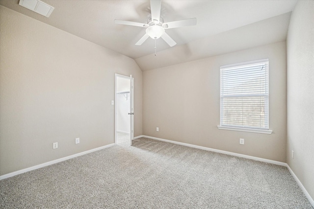 carpeted empty room featuring ceiling fan, baseboards, lofted ceiling, and visible vents