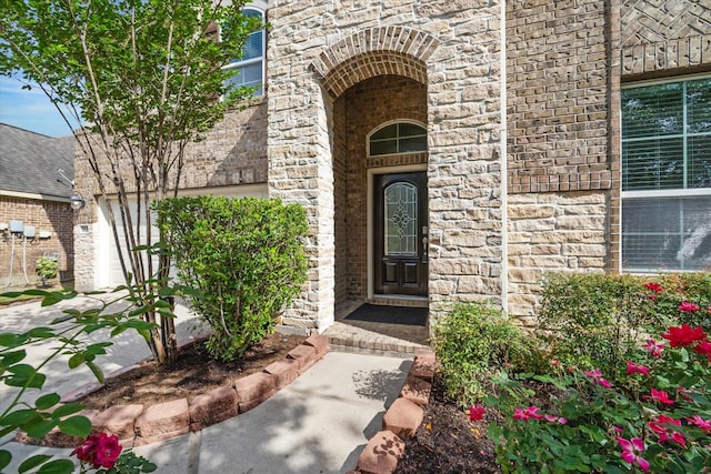 entrance to property featuring stone siding and brick siding