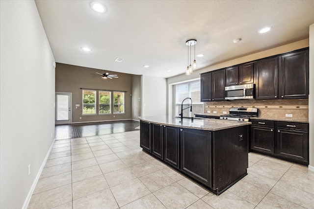 kitchen with a ceiling fan, tasteful backsplash, stainless steel appliances, and light tile patterned floors