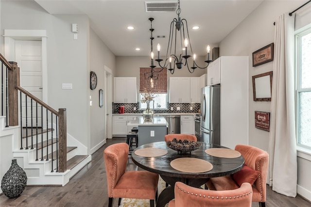 dining area with healthy amount of natural light, dark wood-style flooring, stairway, a chandelier, and recessed lighting