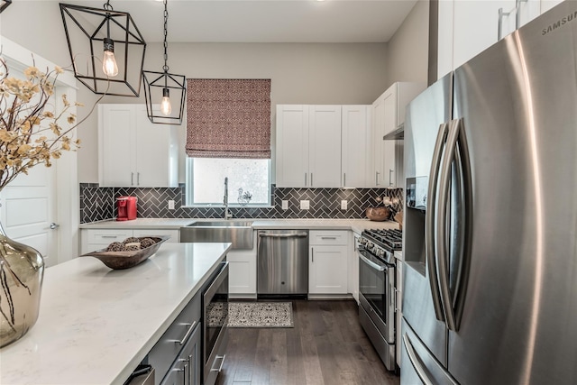 kitchen featuring stainless steel appliances, a sink, dark wood-style floors, white cabinets, and decorative backsplash