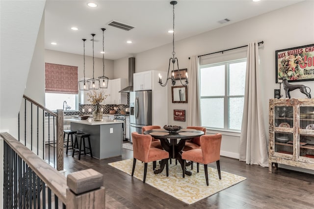 dining room with a chandelier, recessed lighting, dark wood finished floors, and stairway