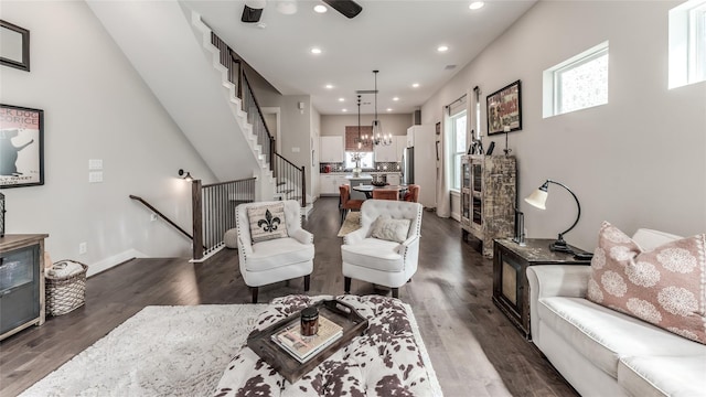 living area with recessed lighting, stairway, dark wood finished floors, a chandelier, and baseboards