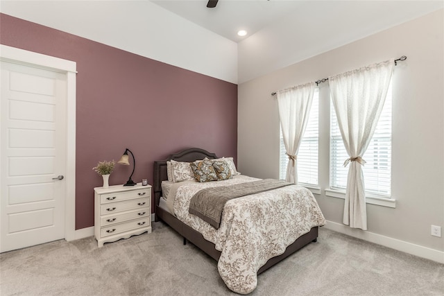 bedroom featuring light colored carpet, baseboards, a ceiling fan, and vaulted ceiling