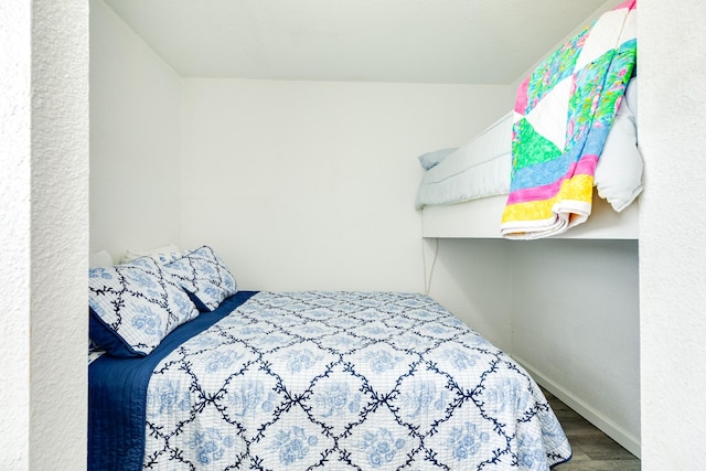 bedroom with wood finished floors and baseboards