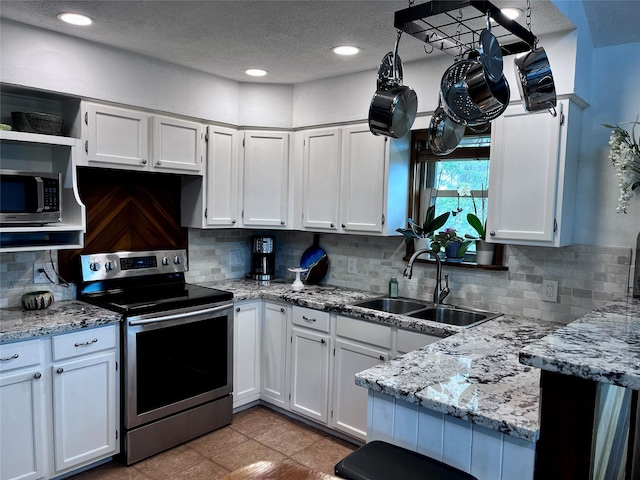 16634 Francis Drake Rd, Jamaica Beach, TX 77554 - kitchen featuring white cabinetry, stainless steel appliances, and a sink
