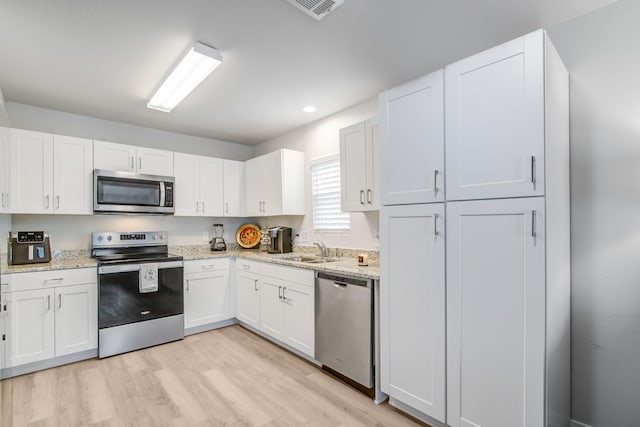 15560 Briar Forest Dr, Conroe, TX 77306 - kitchen with appliances with stainless steel finishes, a sink, white cabinets, and recessed lighting