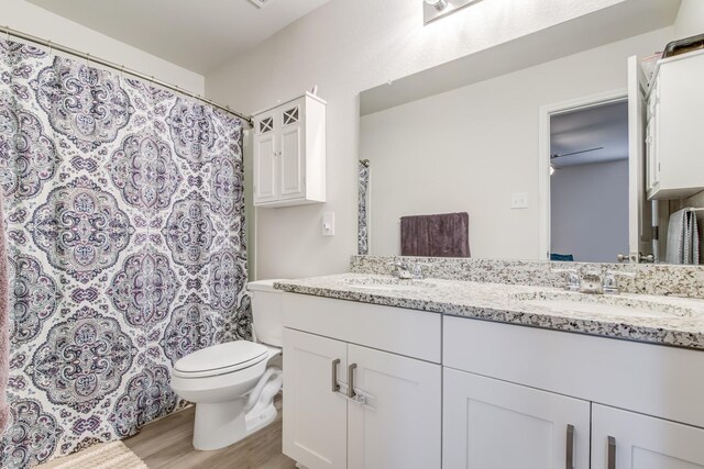 15560 Briar Forest Dr, Conroe, TX 77306 - full bathroom featuring wood finished floors, double vanity, toilet, and curtained shower