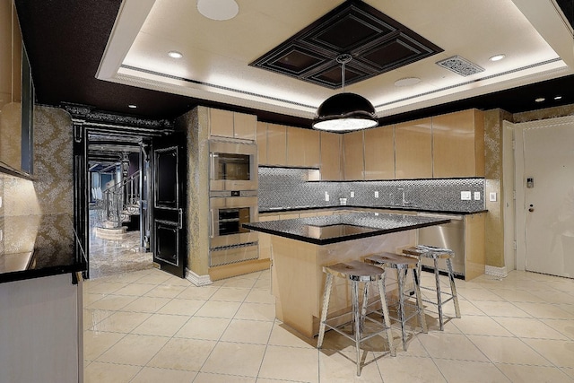 101 Westcott St Unit 2001, Houston, TX 77007 - kitchen with visible vents, a breakfast bar, a tray ceiling, stainless steel appliances, and a kitchen island