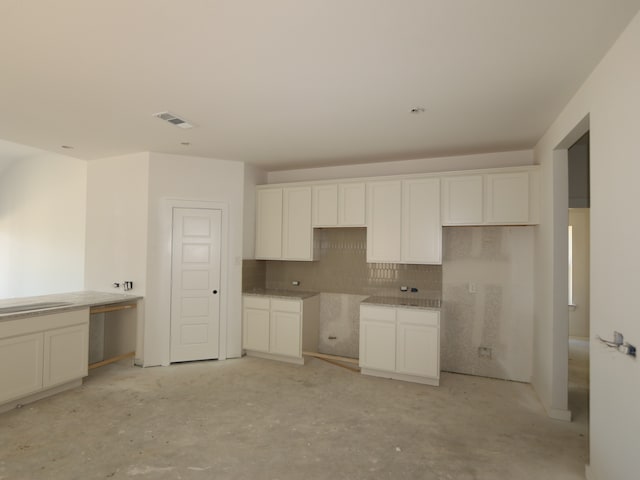 8042 Kay Harbor Dr, Cypress, TX 77433 - kitchen featuring backsplash, concrete floors, and white cabinets