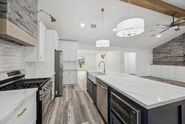kitchen with decorative backsplash, a sink, stainless steel appliances, light wood-type flooring, and vaulted ceiling with beams