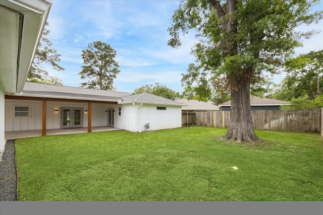 view of yard with a patio area, french doors, and a fenced backyard