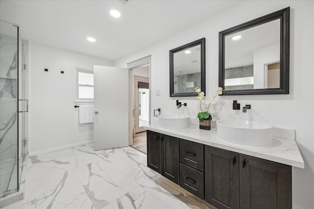 bathroom featuring recessed lighting, a marble finish shower, and a sink