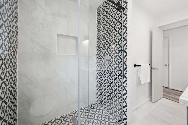 bathroom with baseboards and tiled shower