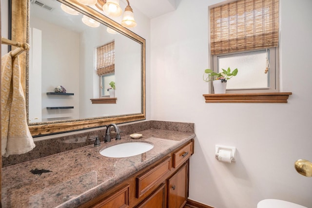 bathroom featuring visible vents, vanity, and toilet