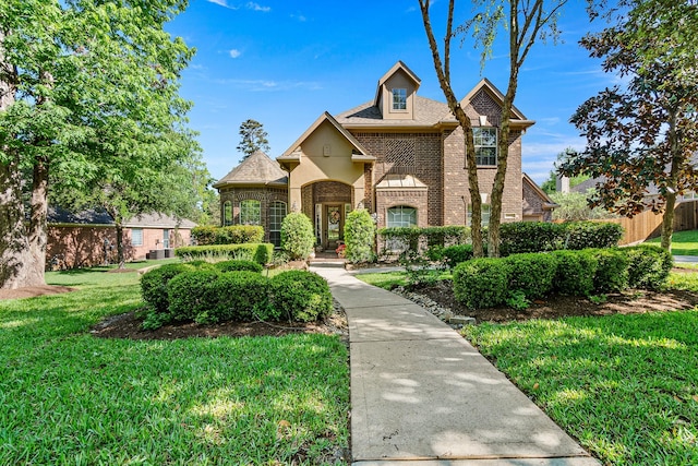 traditional-style home featuring brick siding and a front lawn