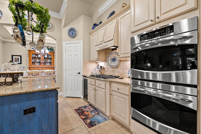 2469 S Bramlet Dr, Conroe, TX 77304 - kitchen featuring crown molding, stainless steel double oven, cream cabinetry, backsplash, and a chandelier