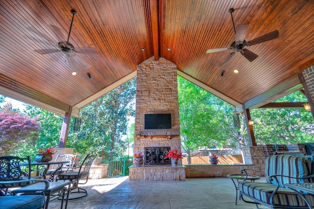 view of patio with an outdoor stone fireplace and ceiling fan