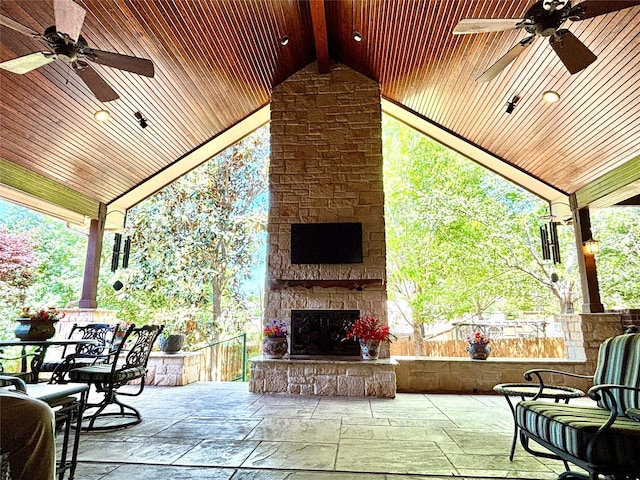 view of patio / terrace with ceiling fan and an outdoor stone fireplace