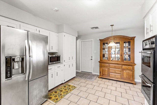 15707 Spring Forest Dr, Houston, TX 77059 - kitchen with appliances with stainless steel finishes, white cabinets, hanging light fixtures, and baseboards