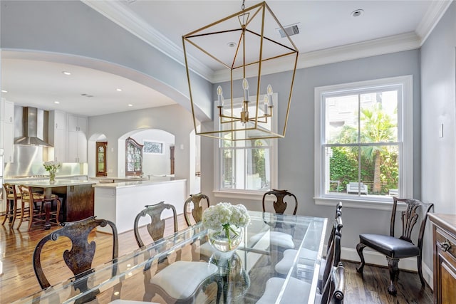 609 Reinicke St, Houston, TX 77007 - dining room featuring arched walkways, visible vents, ornamental molding, and wood finished floors