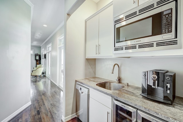 609 Reinicke St, Houston, TX 77007 - kitchen with a sink, white cabinetry, crown molding, and stainless steel appliances