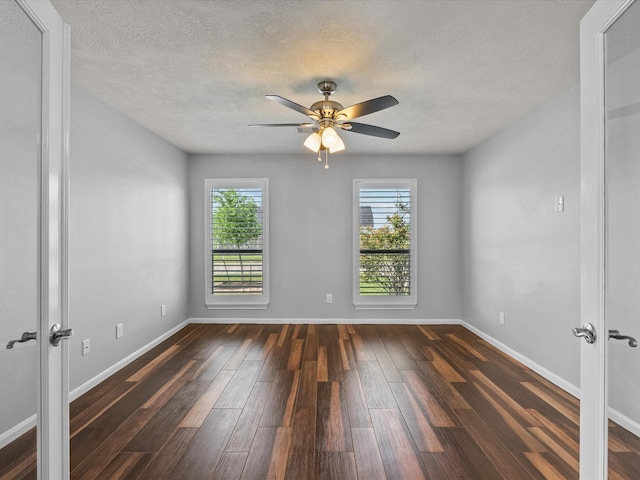 2001 Sedona Dr, League City, TX 77573 - empty room featuring dark wood-type flooring, french doors, a ceiling fan, a textured ceiling, and baseboards