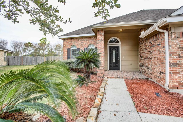 2301 Wimberly Dr, Deer Park, TX 77536 - doorway to property featuring a shingled roof and brick siding