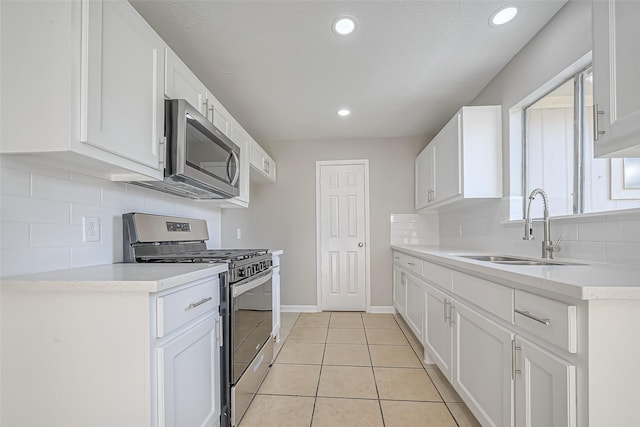8719 Valley Meadow Dr, Houston, TX 77078 - kitchen featuring light tile patterned floors, white cabinetry, appliances with stainless steel finishes, light countertops, and a sink