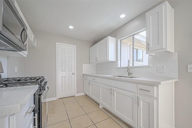 8719 Valley Meadow Dr, Houston, TX 77078 - kitchen with a sink, light countertops, appliances with stainless steel finishes, white cabinetry, and backsplash