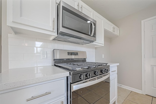 8719 Valley Meadow Dr, Houston, TX 77078 - kitchen featuring tasteful backsplash, light tile patterned floors, white cabinets, and appliances with stainless steel finishes