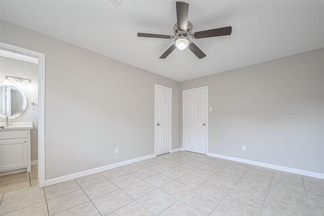 8719 Valley Meadow Dr, Houston, TX 77078 - unfurnished bedroom with light tile patterned flooring, ceiling fan, baseboards, and ensuite bath