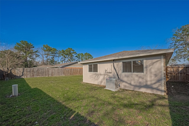 8719 Valley Meadow Dr, Houston, TX 77078 - back of house featuring central AC unit, a fenced backyard, and a lawn