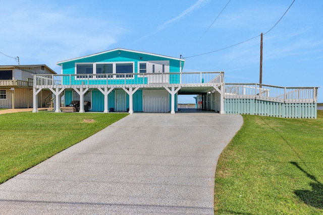 view of front facade featuring a carport, a front lawn, and concrete driveway