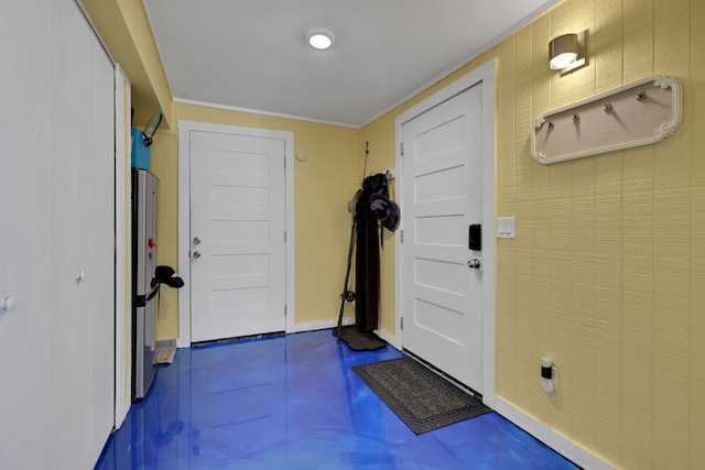 entryway featuring baseboards, concrete flooring, and ornamental molding