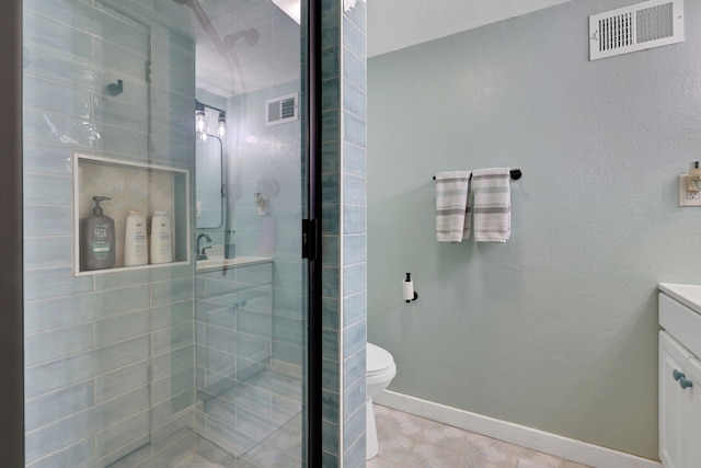 full bath with a stall shower, vanity, baseboards, and visible vents