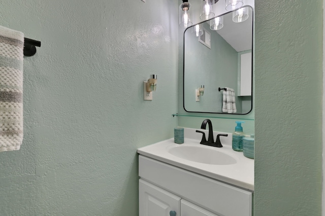 bathroom with a textured wall and vanity