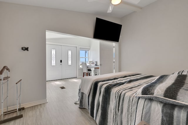 bedroom featuring visible vents, baseboards, a ceiling fan, and wood finished floors