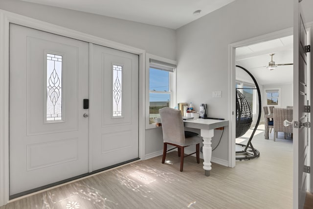 entryway with light wood-style flooring, baseboards, and a ceiling fan