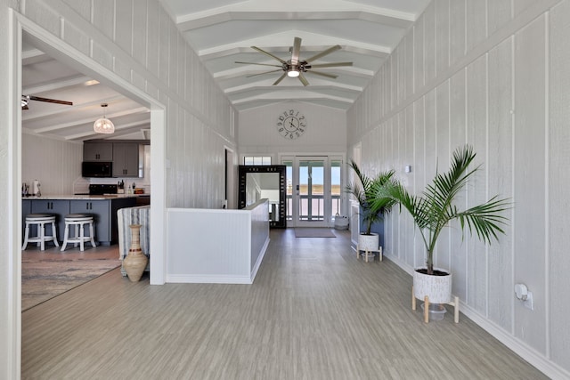 entryway with lofted ceiling with beams, wood finished floors, and ceiling fan